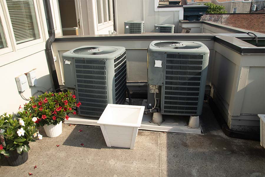 Two outdoor AC units on a concrete patio