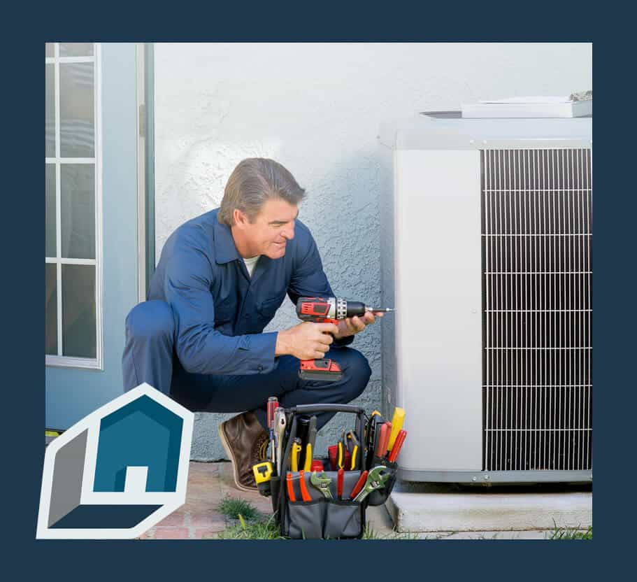 HVAC technician using a drill to service an outdoor AC unit